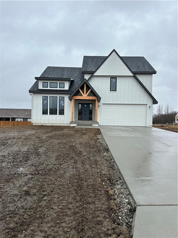 modern inspired farmhouse with a garage, concrete driveway, french doors, roof with shingles, and board and batten siding