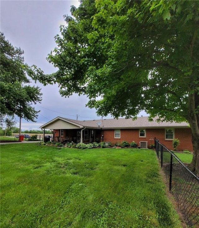 back of property featuring a yard and central air condition unit