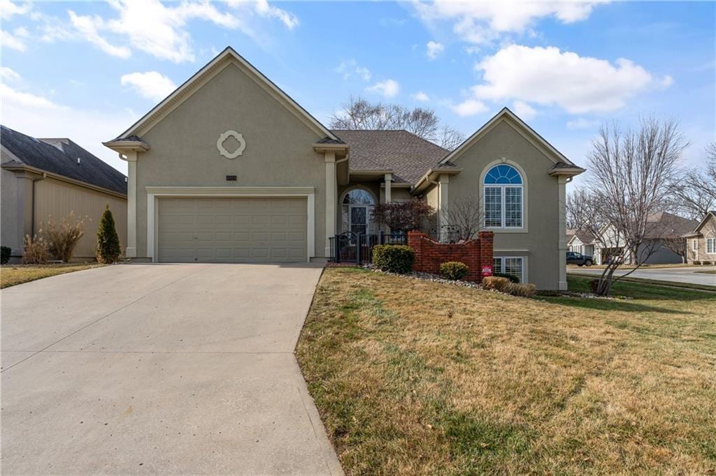 view of front of house with a garage and a front lawn