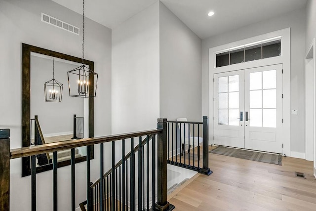 entryway featuring a notable chandelier, wood-type flooring, and french doors