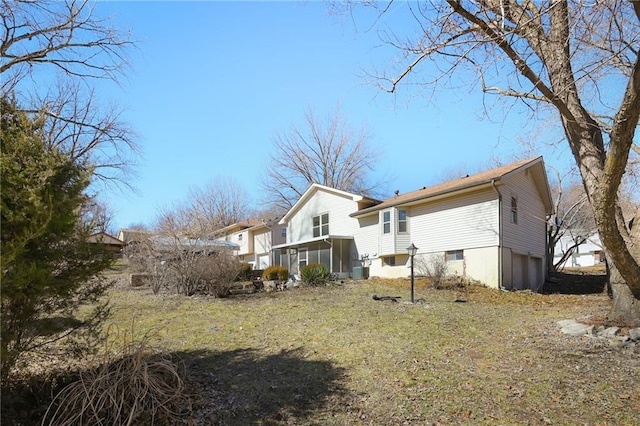 rear view of property with a sunroom and an attached garage