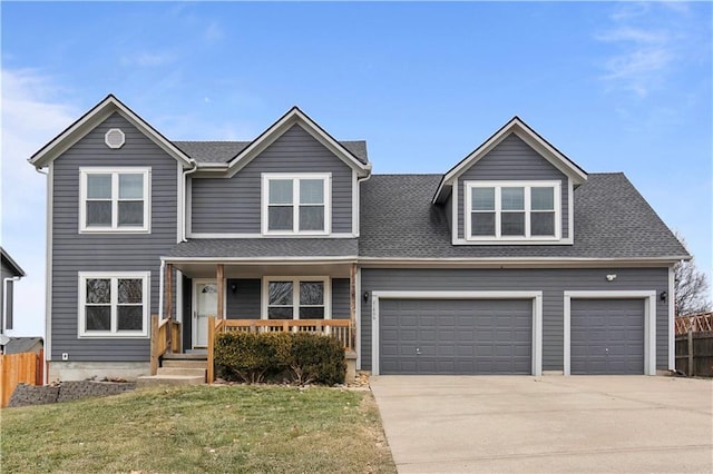 view of front property with a garage, a front yard, and covered porch