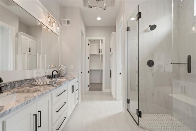 bathroom featuring vanity and a shower with door