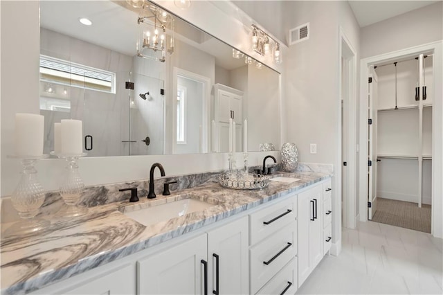 bathroom featuring a shower with door and vanity