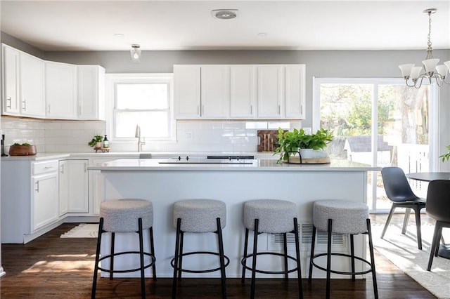 kitchen featuring a kitchen island, a wealth of natural light, hanging light fixtures, and white cabinets