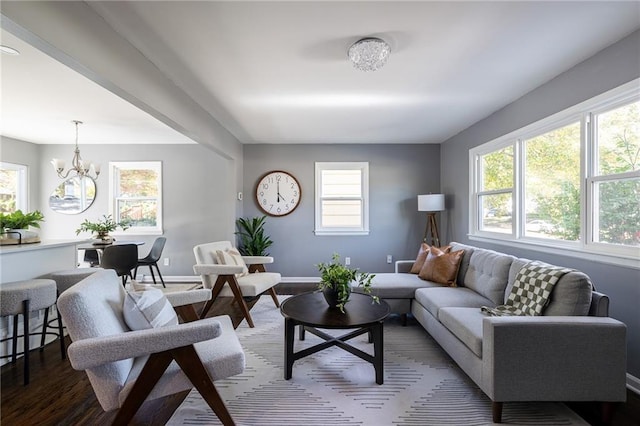 living room featuring a healthy amount of sunlight, wood-type flooring, and a chandelier