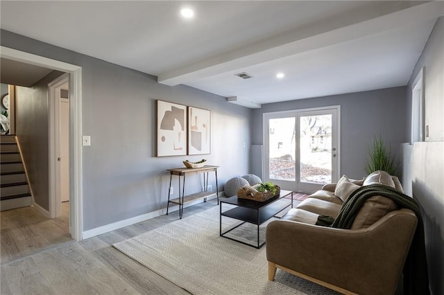 living room with beam ceiling and light hardwood / wood-style flooring