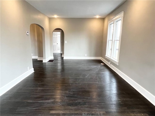 unfurnished room with dark wood-type flooring