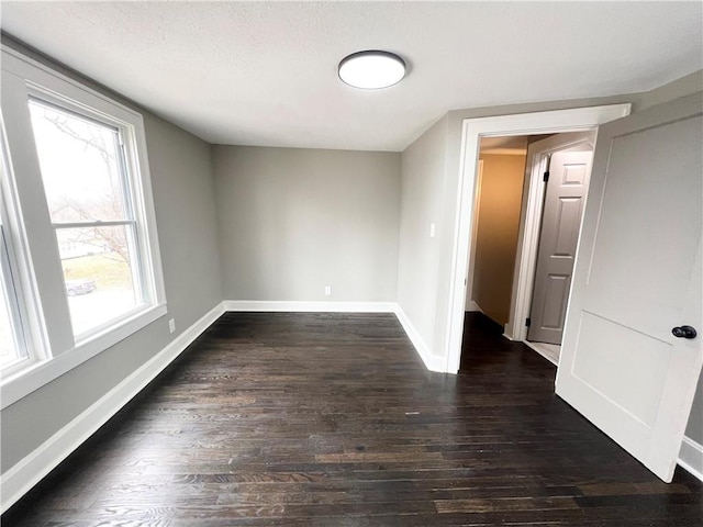 empty room featuring dark hardwood / wood-style floors and a textured ceiling