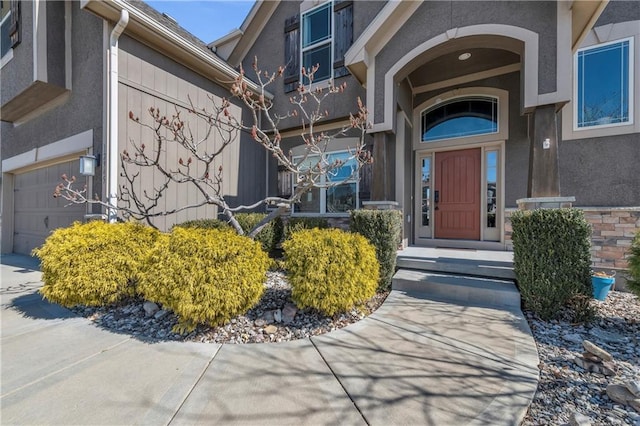 property entrance with an attached garage and stucco siding