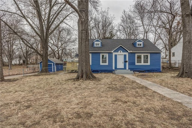 new england style home with a storage shed and a front yard