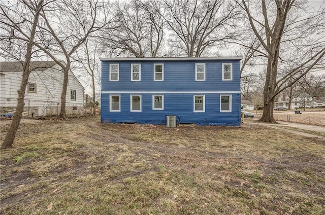 back of property featuring central AC and a lawn