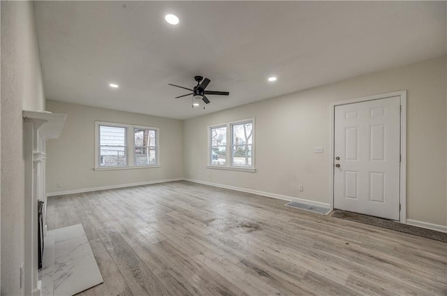 unfurnished living room with ceiling fan and light hardwood / wood-style flooring