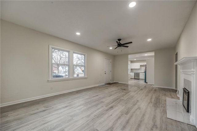 unfurnished living room featuring ceiling fan and light wood-type flooring