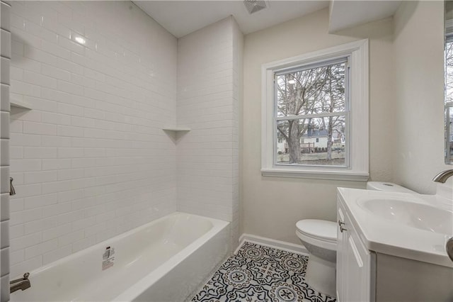 full bathroom with tile patterned flooring, vanity, tiled shower / bath, and toilet