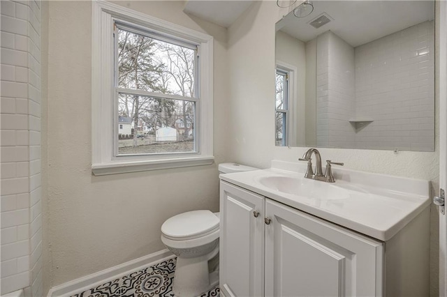 bathroom featuring vanity, a wealth of natural light, and toilet