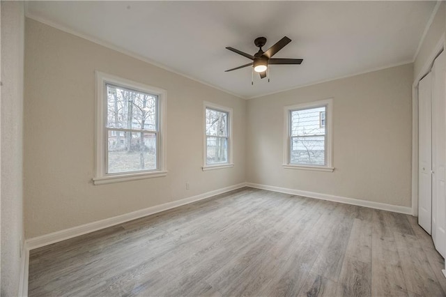 unfurnished bedroom featuring ornamental molding, ceiling fan, light hardwood / wood-style floors, and a closet