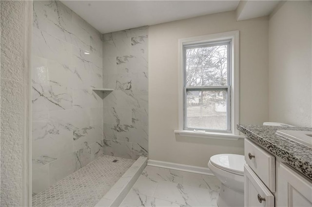 bathroom featuring vanity, a wealth of natural light, toilet, and tiled shower