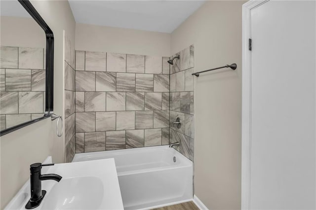 bathroom featuring tiled shower / bath combo, sink, and hardwood / wood-style floors