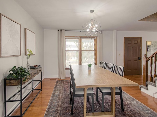 dining space featuring an inviting chandelier and light hardwood / wood-style floors