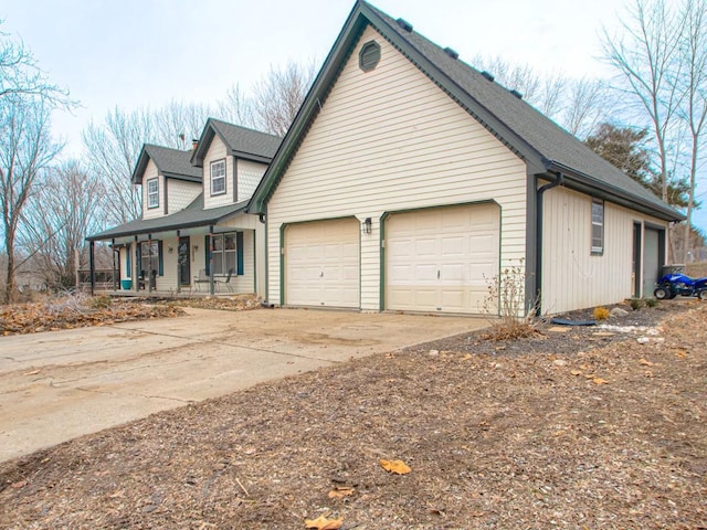 view of side of property with a garage and a porch