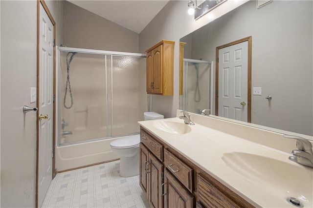 full bathroom with vaulted ceiling, vanity, toilet, and combined bath / shower with glass door