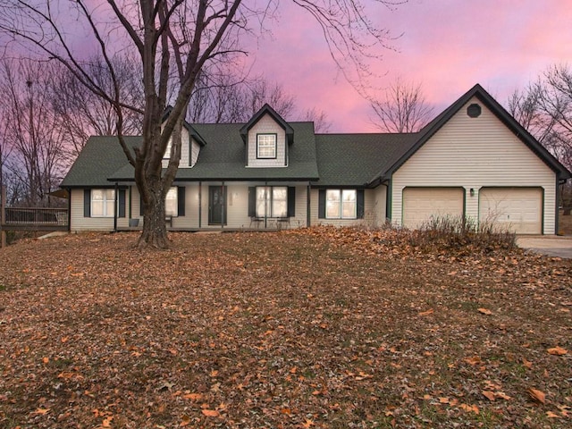 view of front of house featuring an attached garage and a shingled roof