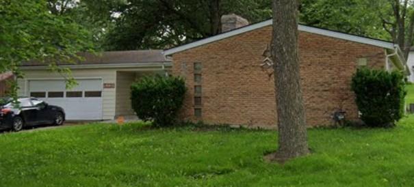 view of home's exterior with an attached garage, a lawn, and a chimney