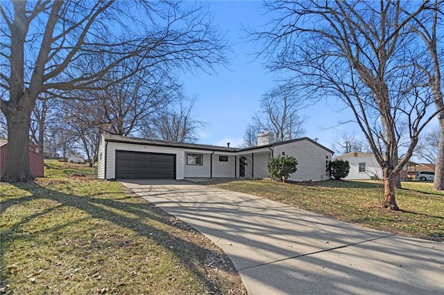 view of front of property featuring a front lawn, a chimney, concrete driveway, and an attached garage