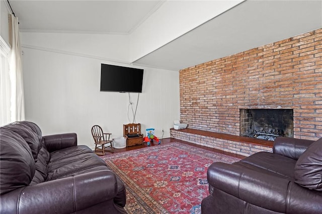 living room featuring a fireplace, brick wall, and crown molding