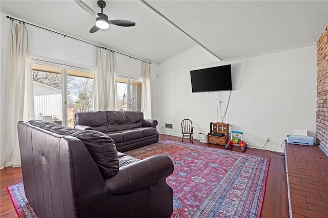 living area with baseboards, a ceiling fan, and vaulted ceiling