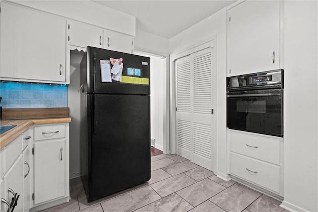 kitchen featuring white cabinetry, black appliances, light countertops, and decorative backsplash