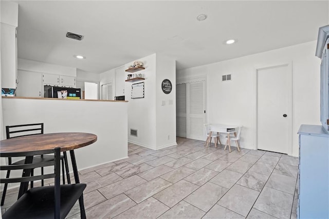 kitchen with visible vents, recessed lighting, refrigerator, and white cabinetry