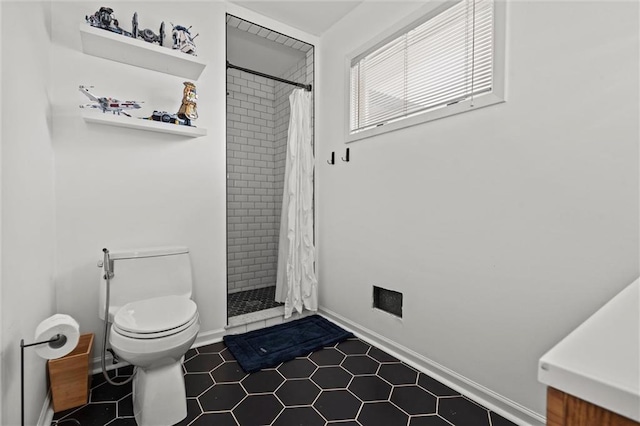 full bathroom featuring a stall shower, toilet, and baseboards