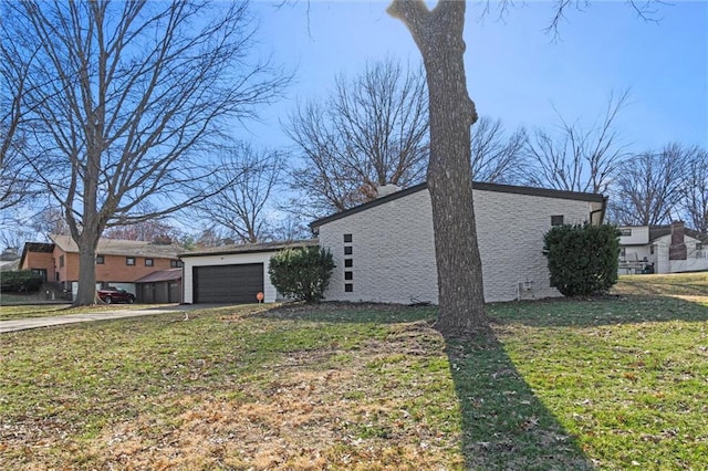 view of side of property featuring a garage, driveway, and a yard