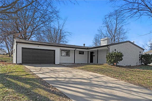 view of front of house featuring a garage, brick siding, a chimney, and driveway