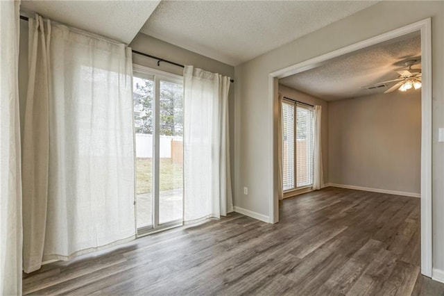 spare room featuring ceiling fan, wood-type flooring, and a textured ceiling