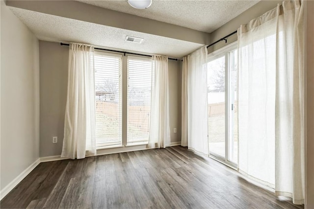 spare room with hardwood / wood-style flooring and a textured ceiling