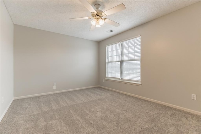 unfurnished room with a textured ceiling, light colored carpet, and ceiling fan