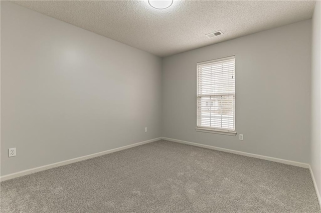 carpeted spare room featuring a textured ceiling