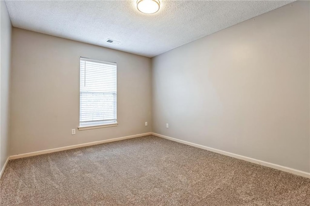 empty room with carpet flooring and a textured ceiling