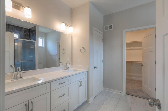 full bath featuring visible vents, a shower stall, toilet, and a sink