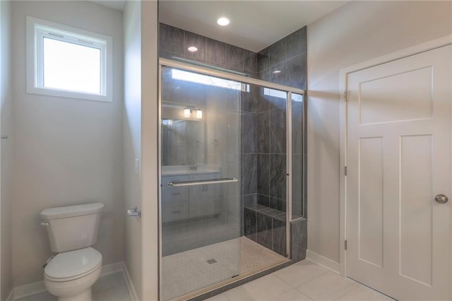 bathroom with toilet, tile patterned flooring, a stall shower, and baseboards