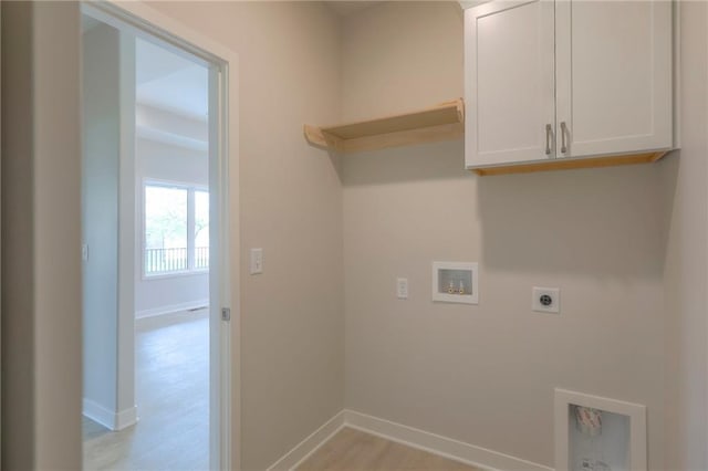 washroom featuring hookup for an electric dryer, cabinet space, washer hookup, light wood-type flooring, and baseboards