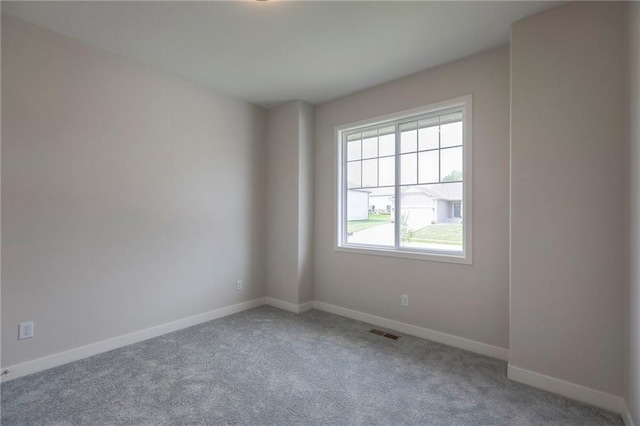 spare room featuring visible vents, carpet flooring, and baseboards