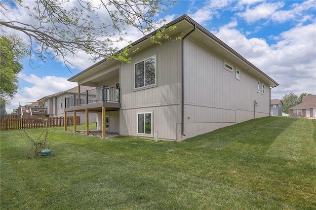 rear view of property with fence and a lawn