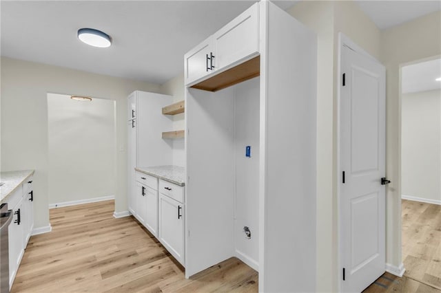 kitchen featuring white cabinetry, dishwasher, light hardwood / wood-style floors, and light stone counters