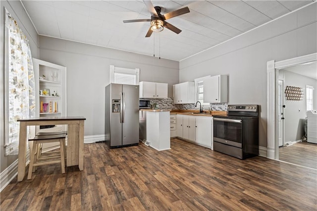 kitchen with white cabinets, dark wood finished floors, stainless steel appliances, and a sink