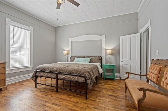 bedroom featuring ceiling fan, wood finished floors, and baseboards