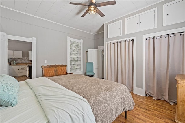 bedroom featuring vaulted ceiling, light wood-style flooring, and a ceiling fan